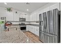 Well-lit kitchen featuring stainless steel appliances, granite countertops, and ample white cabinet space at 7456 Cooks Meadow St, North Las Vegas, NV 89084