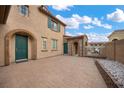 Charming home featuring a paved courtyard with stone accents and beautiful landscaping at 7825 Alameda Creek St, Las Vegas, NV 89113