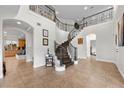 Grand foyer with a curved staircase, tile flooring, arched doorways, and elegant wrought iron railing at 7825 Alameda Creek St, Las Vegas, NV 89113