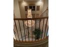 Staircase and foyer with hardwood railing and ornate chandelier at 9301 Harrow Rock St, Las Vegas, NV 89143