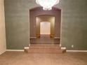 A hallway featuring neutral-colored walls, tile flooring, and an arched doorway at 9301 Harrow Rock St, Las Vegas, NV 89143