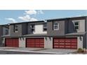 Exterior of modern townhomes showcasing brick-red garage doors and updated outdoor lighting at 9451 Calm Stream Ave # Lot 81, Las Vegas, NV 89178