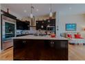 Modern kitchen with dark cabinets, stainless steel appliances, and a central island at 11477 Timber Mountain Ave, Las Vegas, NV 89135