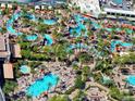 Aerial view of resort pools surrounded by palm trees and lounge chairs for a relaxing vacation experience at 145 E Harmon Ave # 3005, Las Vegas, NV 89109