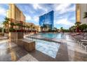 Relaxing pool and spa area with lounge chairs and palm trees near buildings on a sunny day at 145 E Harmon Ave # 3005, Las Vegas, NV 89109