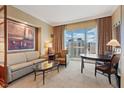 Comfortable living room area with a couch, chairs, and a table, with city views visible through the large window at 145 E Harmon Ave # 3007, Las Vegas, NV 89109