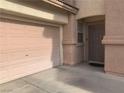 Home exterior featuring a garage and front door, complemented by clean landscaping and a welcoming entrance at 1463 Evening Song Ave, Henderson, NV 89012