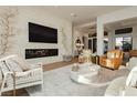 Sophisticated living room with a stone fireplace, large screen TV, and comfortable seating arrangement at 19 Isleworth Dr, Henderson, NV 89052