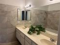 Bathroom with modern tile, double sinks, white cabinets and a plant in front of the mirror at 228 Moose Ln, Las Vegas, NV 89145