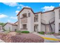 Exterior view of a condo building with private balconies, landscaped grounds, and convenient access to stairs and parking at 2615 W Gary Ave # 1028, Las Vegas, NV 89123