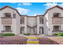 Symmetrical view of the condo building's exterior, featuring private balconies, well-maintained landscaping, and shared staircases at 2615 W Gary Ave # 1028, Las Vegas, NV 89123