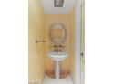 Cozy half bath featuring pedestal sink with oval mirror and neutral walls at 2777 Paradise Rd # 1208, Las Vegas, NV 89109