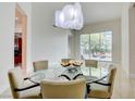 Dining room with statement light fixture, glass table, and views of the outdoor patio at 2877 Paradise Rd # 104, Las Vegas, NV 89109