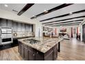 Island kitchen with granite counters and dark wood beam ceiling views the living room at 296 Brushy Creek Ave, Las Vegas, NV 89148