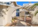 Charming front entryway with a unique arched pergola and blue double doors at 3588 Franciscan Ln, Las Vegas, NV 89121