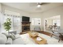 Bright living room featuring a stone fireplace, wood floors, and a view into the kitchen at 430 Nancy Dr, Henderson, NV 89015