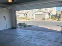 Spacious, two-car garage with an outside view of the neighborhood homes and driveways at 5773 Fresh Fields Ct, Las Vegas, NV 89118