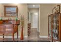 Neutral hallway boasts a display cabinet, console table with decor, and doorway leading to other rooms at 64 Strada Principale # 307, Henderson, NV 89011