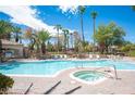Community pool with spa, lounge chairs, and mature palm trees at 6480 Annie Oakley Dr # 614, Las Vegas, NV 89120