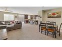 Open floor plan features living room with sectional sofa and dining area with dark wood table and chairs at 6814 Willowcroft St, Las Vegas, NV 89149