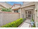 Inviting front entrance with a wrought-iron gate, well-maintained landscaping, and neutral stucco at 7131 Mission Hills Dr, Las Vegas, NV 89113