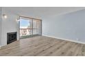 Bright living room featuring wood flooring, modern light-blue paint, and a fireplace with sliding glass doors to the balcony at 725 N Royal Crest Cir # 237, Las Vegas, NV 89169