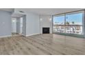 Bright living room featuring wood flooring, modern light-blue paint, and a fireplace with sliding glass doors to the balcony at 725 N Royal Crest Cir # 237, Las Vegas, NV 89169