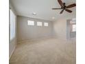 Bright and airy living room with neutral carpet, a ceiling fan, and plenty of natural light at 8348 Mokena Ave, Las Vegas, NV 89178