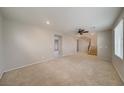 Spacious living room with neutral carpet, ceiling fan, staircase, and ample natural light at 8348 Mokena Ave, Las Vegas, NV 89178