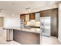 Modern kitchen features stainless steel appliances, dark cabinetry and an island with granite countertop at 8925 W Flamingo Rd # 310, Las Vegas, NV 89147