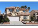 Inviting two-story home with a terra cotta tile roof, a well-manicured lawn and a two car garage at 8982 Emerald Waters Ct, Las Vegas, NV 89147
