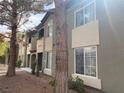 Exterior shot of building with tan and gray stucco, dark trim, and mature trees at 9000 Las Vegas Blvd # 1271, Las Vegas, NV 89123