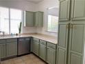 Bright kitchen features light green cabinets with gold hardware, and light countertops at 9236 Canalino Dr, Las Vegas, NV 89134