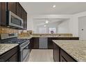 Well-equipped kitchen with granite countertops, stainless steel appliances, and dark wood cabinetry at 1026 Via Saint Andrea Pl, Henderson, NV 89011