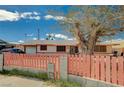 Charming single-story home featuring a large mature tree with a decorative pink fence in the front yard at 111 Narcissus Ln, Las Vegas, NV 89107