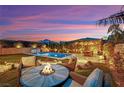 Serene backyard featuring a pool, spa, manicured lawn, built in BBQ and comfortable seating area with fire pit at 11878 Albissola Ave, Las Vegas, NV 89138