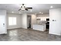 Open-concept living area and kitchen with tile floors, stainless steel appliances, and an island at 12800 Oceano Dunes Ct, Henderson, NV 89044
