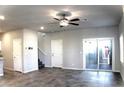 Open-concept living area with tile floors, ceiling fan, and access to a patio via sliding glass doors at 12800 Oceano Dunes Ct, Henderson, NV 89044