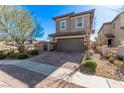 Two-story home featuring desert landscaping, a paved driveway, and a two-car garage at 173 Volti Subito Way, Henderson, NV 89011