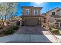 Beautiful two-story home featuring desert landscaping, a paved driveway, and a two-car garage at 173 Volti Subito Way, Henderson, NV 89011