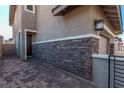 Stylish home exterior with stone accents, a private entrance, and a paved walkway at 173 Volti Subito Way, Henderson, NV 89011