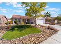Inviting single-story home with a neat front yard, rock garden, and a comfortable sitting bench at 206 Lynbrook St, Henderson, NV 89012