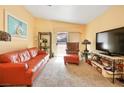 Bright living room with peach walls, neutral carpet, and sliding glass doors to the exterior at 2110 Los Feliz St # 2064, Las Vegas, NV 89156