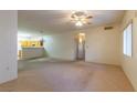 Expansive living room with natural light and neutral carpet, flowing into the kitchen at 2152 Turquoise Ridge St # 105, Las Vegas, NV 89117