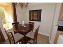 Elegant dining area with a round wooden table and four chairs, lit by a chandelier at 230 E Flamingo Rd # 229, Las Vegas, NV 89169