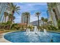 Lush landscaping surrounds water feature in a community near high-rise buildings and a sunny blue sky at 2777 Paradise Rd # 301, Las Vegas, NV 89109