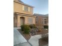 Charming home exterior featuring a stone landscape design and tan siding, complemented by a cozy covered entryway at 312 Sierra Breeze Ave, North Las Vegas, NV 89031