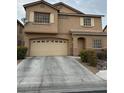 Two-story home featuring tan siding, white shutters, a two-car garage, and well-maintained landscaping at 312 Sierra Breeze Ave, North Las Vegas, NV 89031
