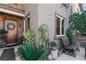 Inviting front entrance with a charming garden, seating area and a decorative wreath on the front door at 3185 Mura Del Prato Ave, Henderson, NV 89044