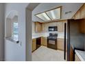 Kitchen featuring black appliances, light wood cabinets, tile backsplash and window with a view at 331 Seine Way # 331, Henderson, NV 89014